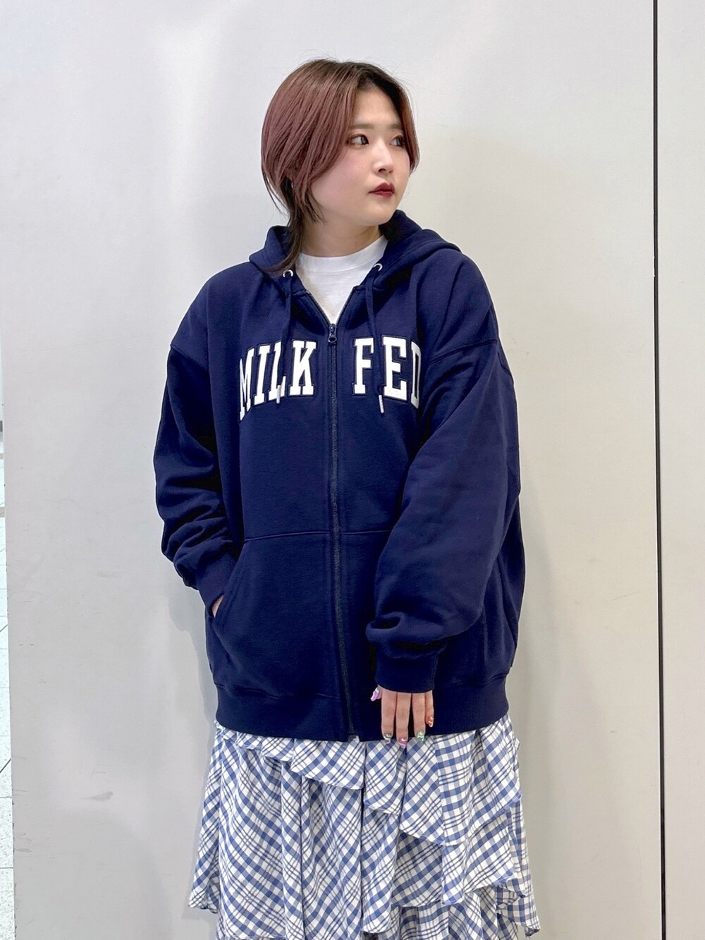 ブルー系のパーカー、ブルー系のスカート、ホワイト系のTシャツ/カットソーを着用したレディースの冬コーディネートの5枚目の写真