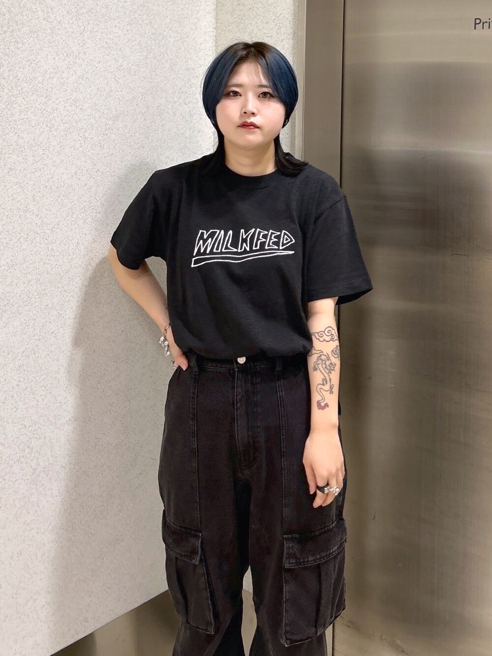 ブラック系のTシャツ/カットソー、ブラック系のカーゴパンツ、ベージュ系のショルダーバッグを着用したレディースの夏コーディネートの4枚目の写真