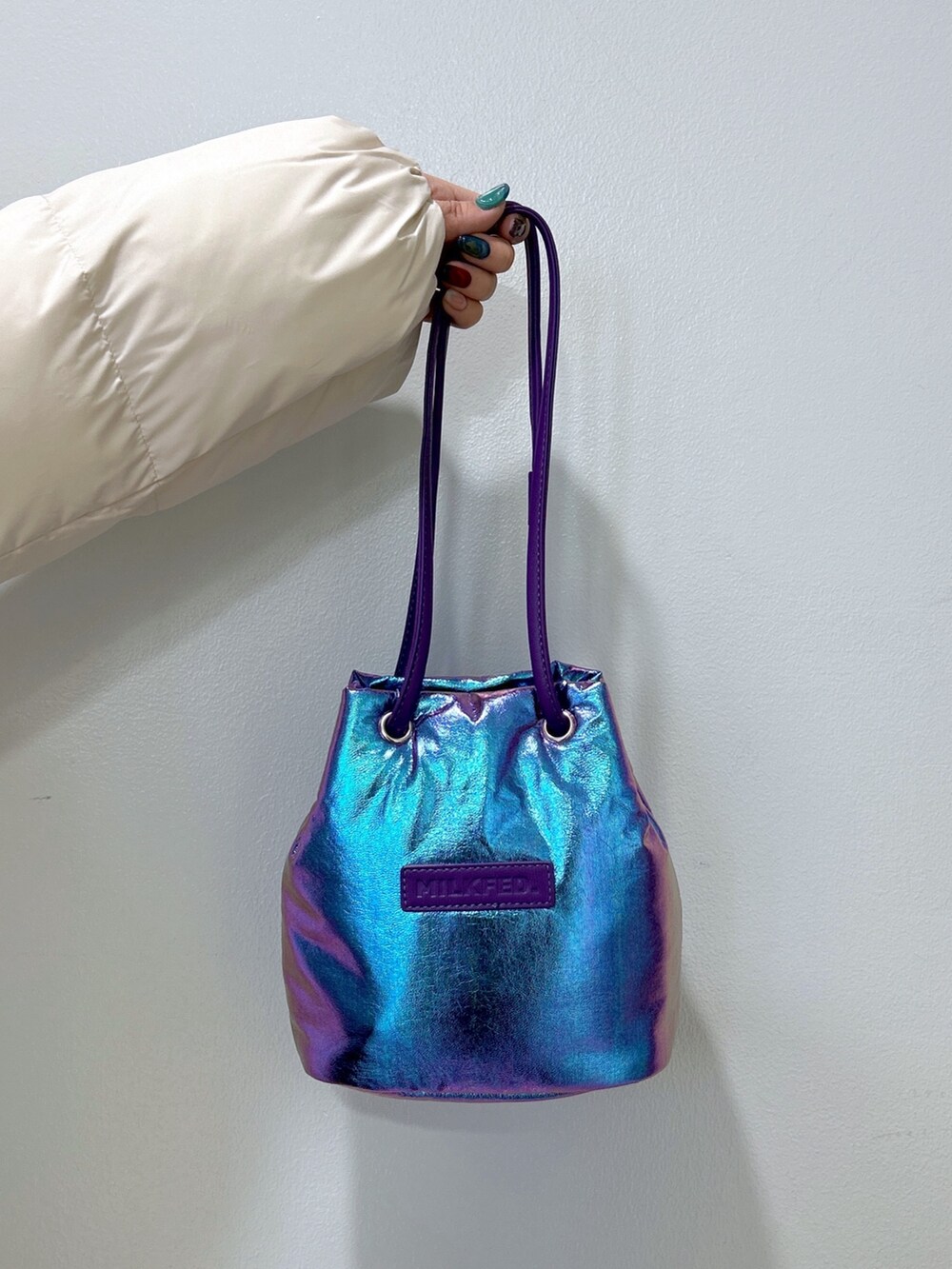 ホワイト系のダウンジャケット/コート、ブラック系のワンピース、パープル系のショルダーバッグを着用したレディースの冬コーディネートの4枚目の写真