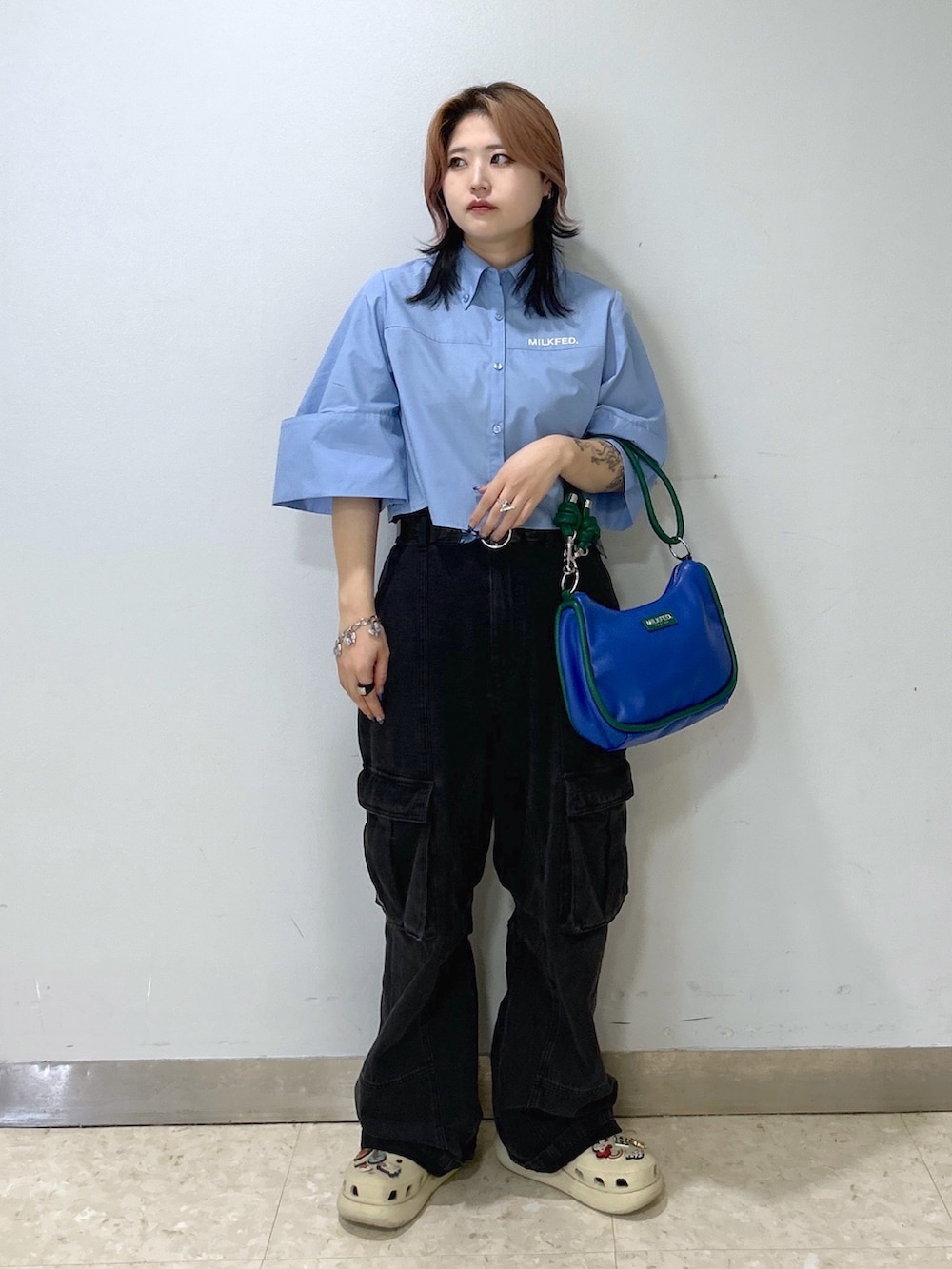 ブルー系のショルダーバッグ、ベージュ系のサンダル、ブルー系のシャツ/ブラウスを着用したレディースの夏コーディネートの2枚目の写真