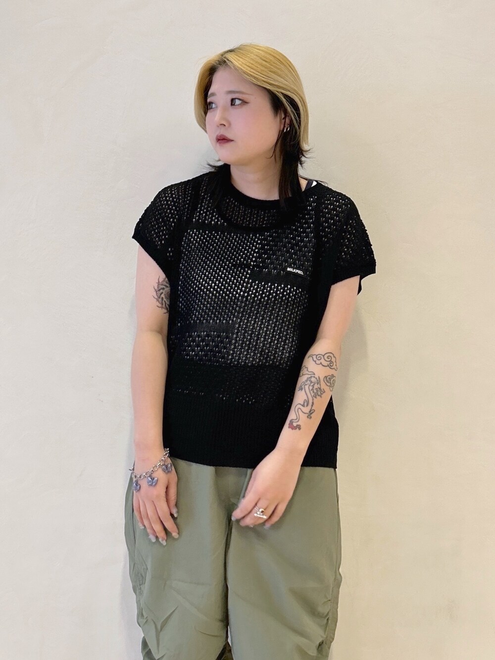 グリーン系のその他パンツ、ブラック系のTシャツ/カットソー、ホワイト系のタンクトップを着用したレディースの春コーディネートの3枚目の写真