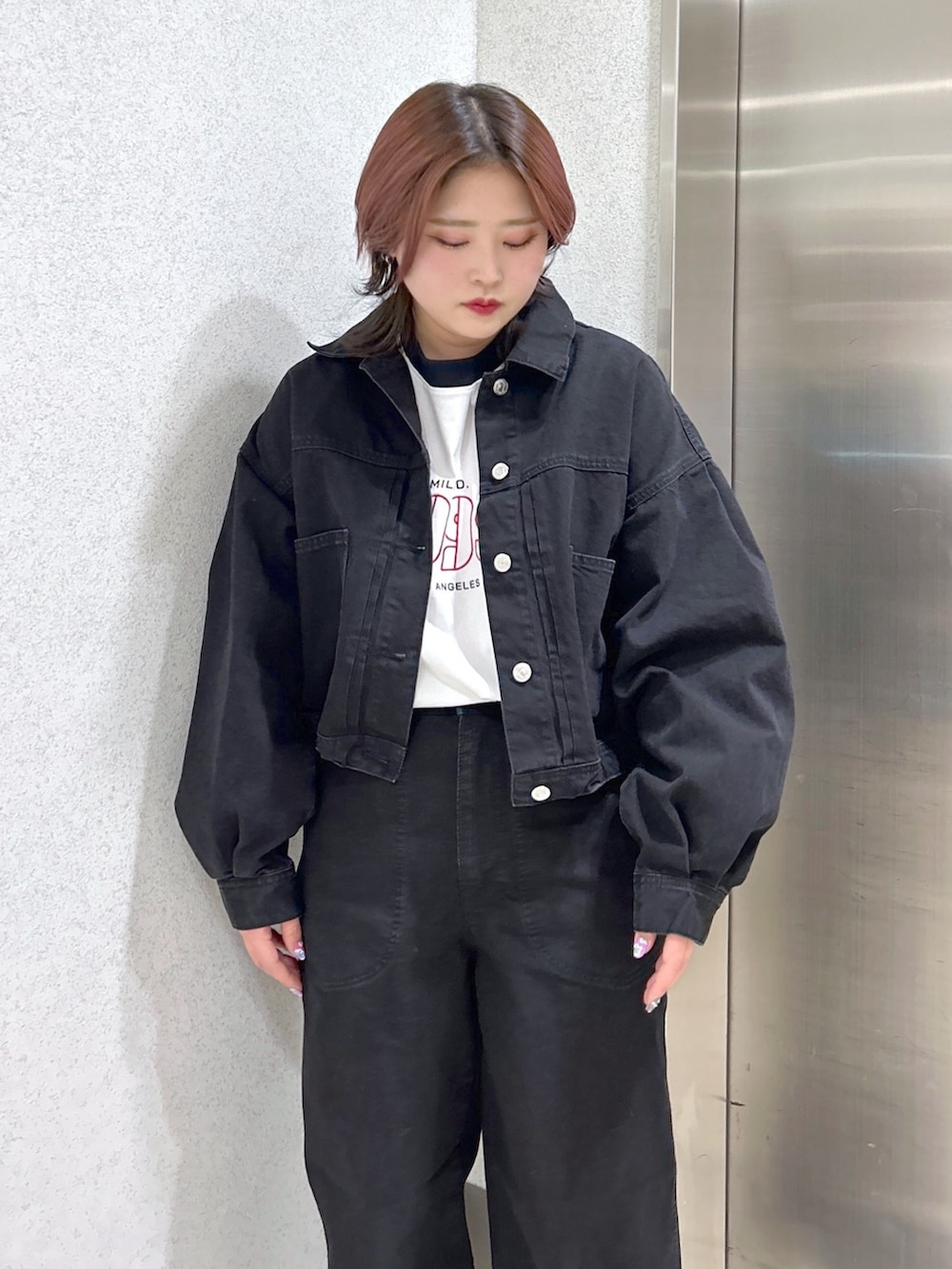 ブラック系のデニムジャケット、ブラック系のデニムパンツ、ブラック系のブーツを着用したレディースの冬コーディネートの5枚目の写真