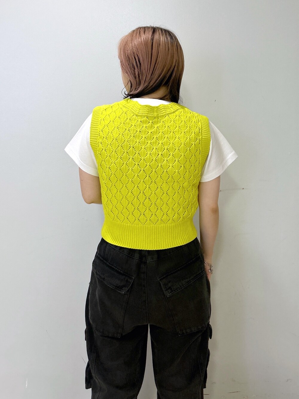 ホワイト系のTシャツ/カットソー、イエロー系のベスト、ブラック系のカーゴパンツを着用したレディースの夏コーディネートの7枚目の写真
