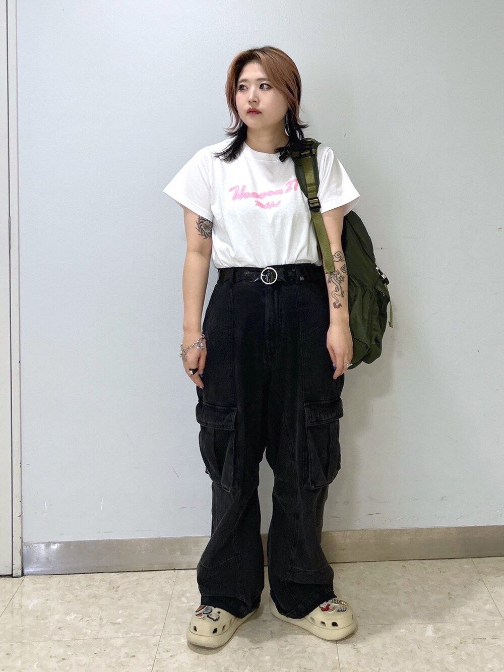 ベージュ系のサンダル、グリーン系のバックパック/リュック、ホワイト系のTシャツ/カットソーを着用したレディースの夏コーディネートの3枚目の写真