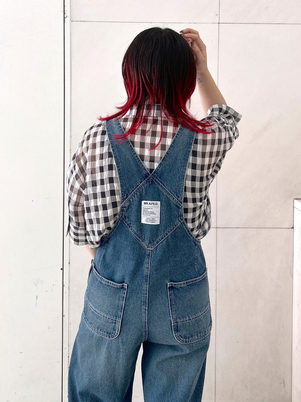 ブラック系のシャツ/ブラウス、ブルー系のサロペット/オーバーオール、レッド系のショルダーバッグを着用したレディースの夏コーディネートの3枚目の写真