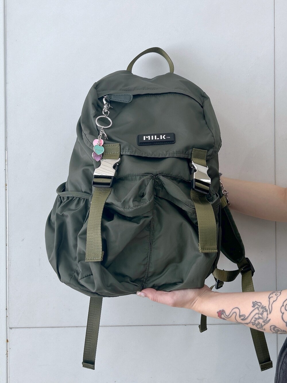 グレー系のTシャツ/カットソー、グリーン系のバックパック/リュック、ブラック系のカーゴパンツを着用したレディースの春コーディネートの7枚目の写真