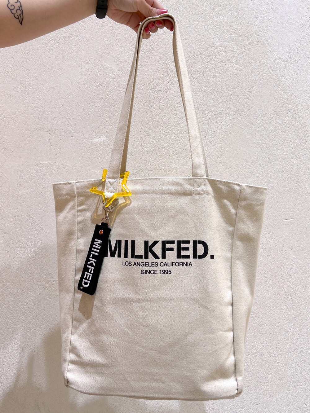 オレンジ系のTシャツ/カットソー、ブラック系のその他パンツ、ブラック系のトートバッグを着用したレディースの夏コーディネートの4枚目の写真