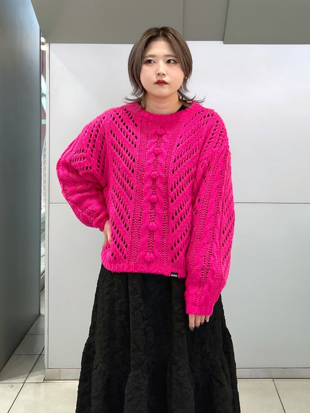 ピンク系のニット/セーター、ブラック系のワンピース、ブラウン系のショルダーバッグを着用したレディースの冬コーディネートの3枚目の写真