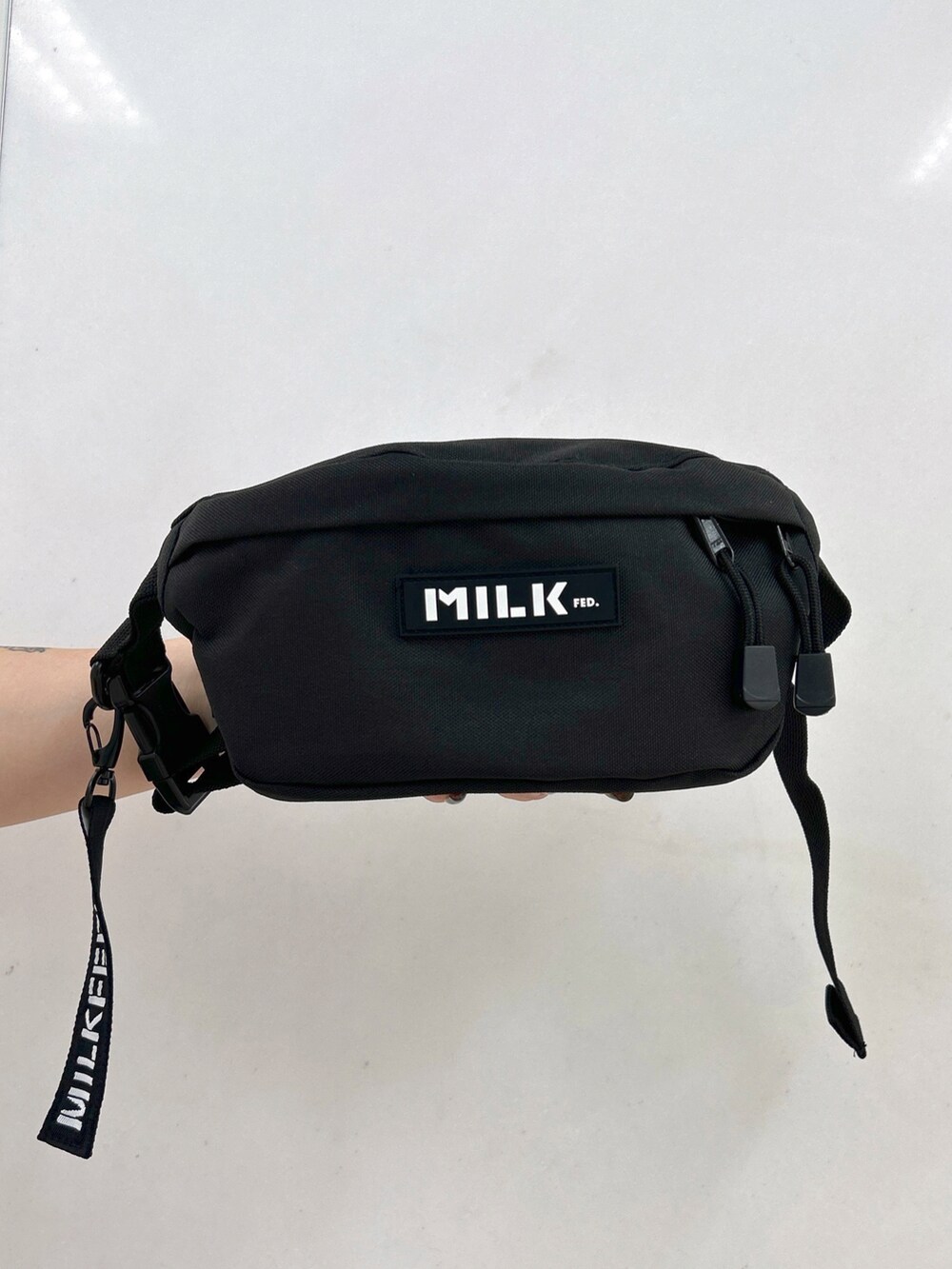 ホワイト系のシャツ/ブラウス、ブラック系のボディバッグ/ウエストポーチ、レッド系のスカートを着用したレディースの夏コーディネートの4枚目の写真