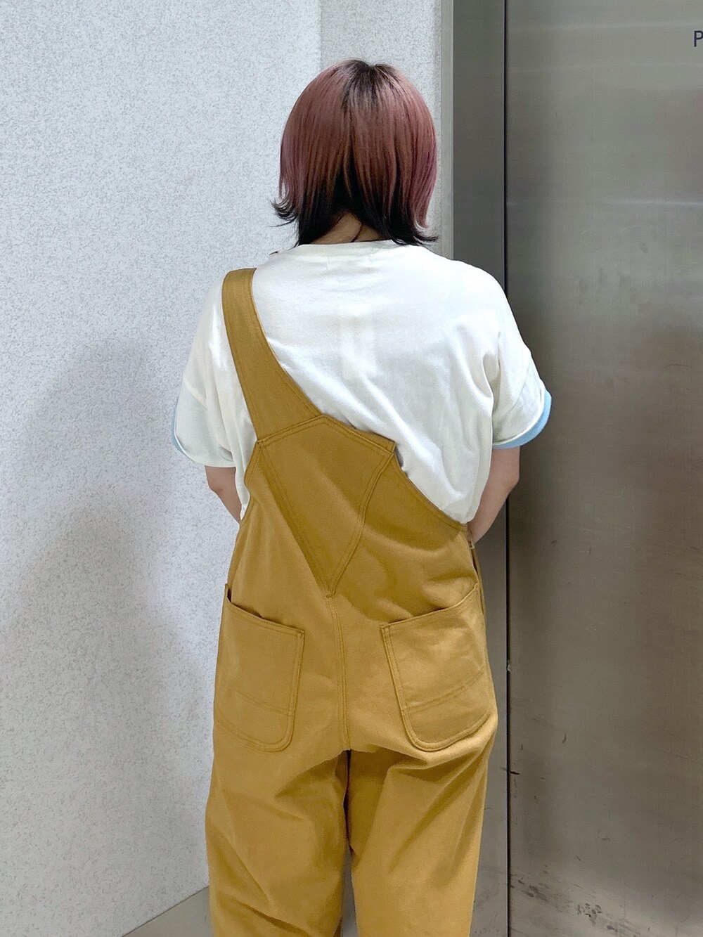 ベージュ系のサロペット/オーバーオール、ホワイト系のTシャツ/カットソー、ブラック系のブーツを着用したレディースの夏コーディネートの7枚目の写真