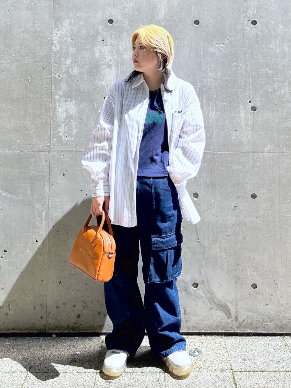 ブルー系のTシャツ/カットソー、ブラウン系のボストンバッグ、ブルー系のカーゴパンツを着用したレディースの春コーディネートの2枚目の写真