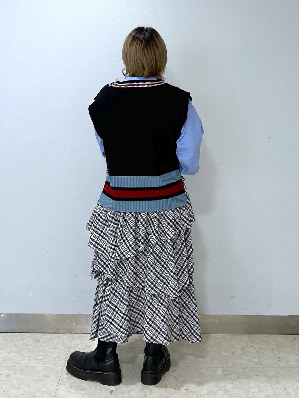 ブラック系のベスト、ブルー系のTシャツ/カットソー、ブラック系のスカートを着用したレディースの冬コーディネートの4枚目の写真