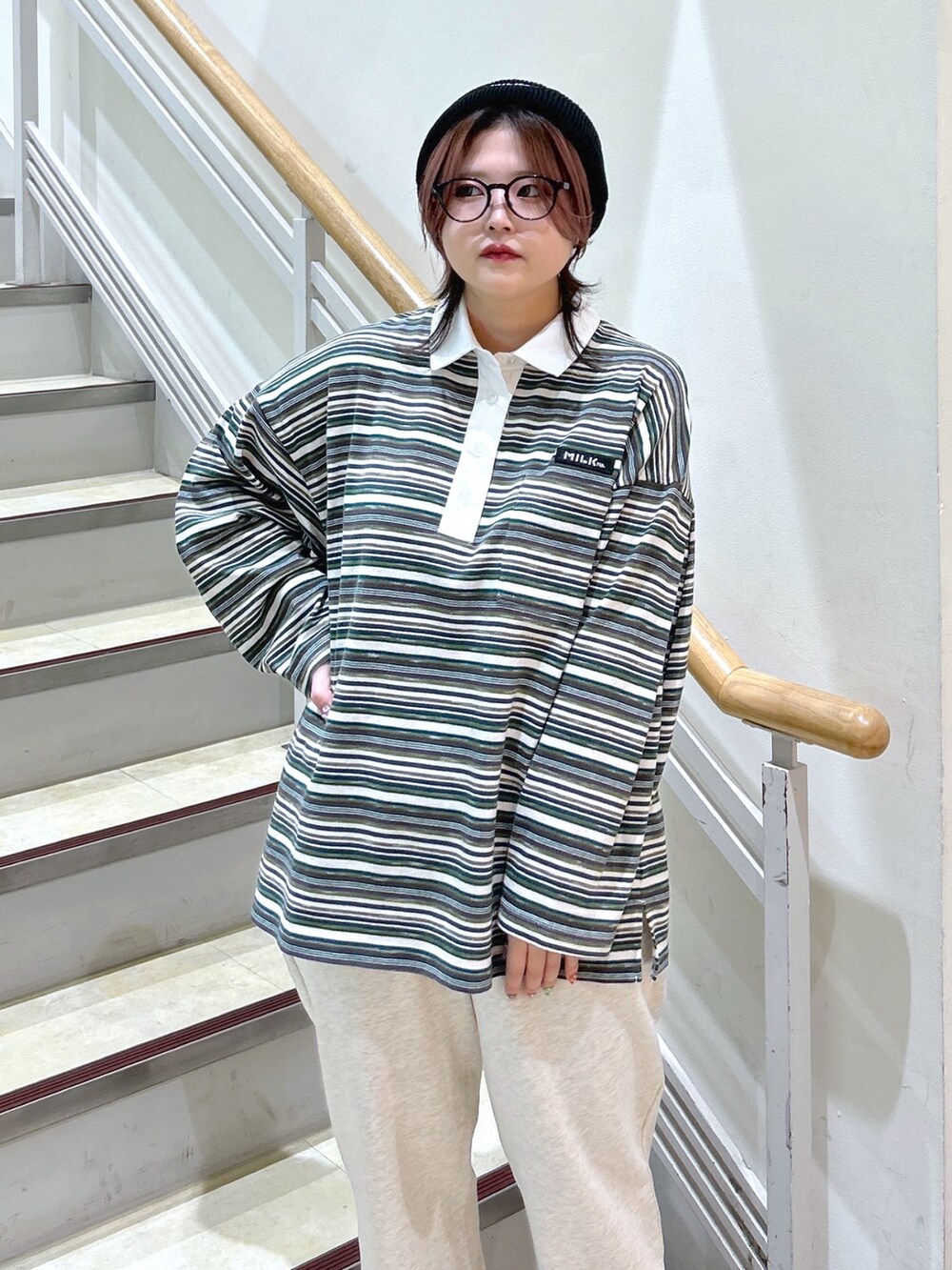 グリーン系のポロシャツ、ベージュ系のスウェットパンツ、グリーン系のバックパック/リュックを着用したレディースの冬コーディネートの8枚目の写真