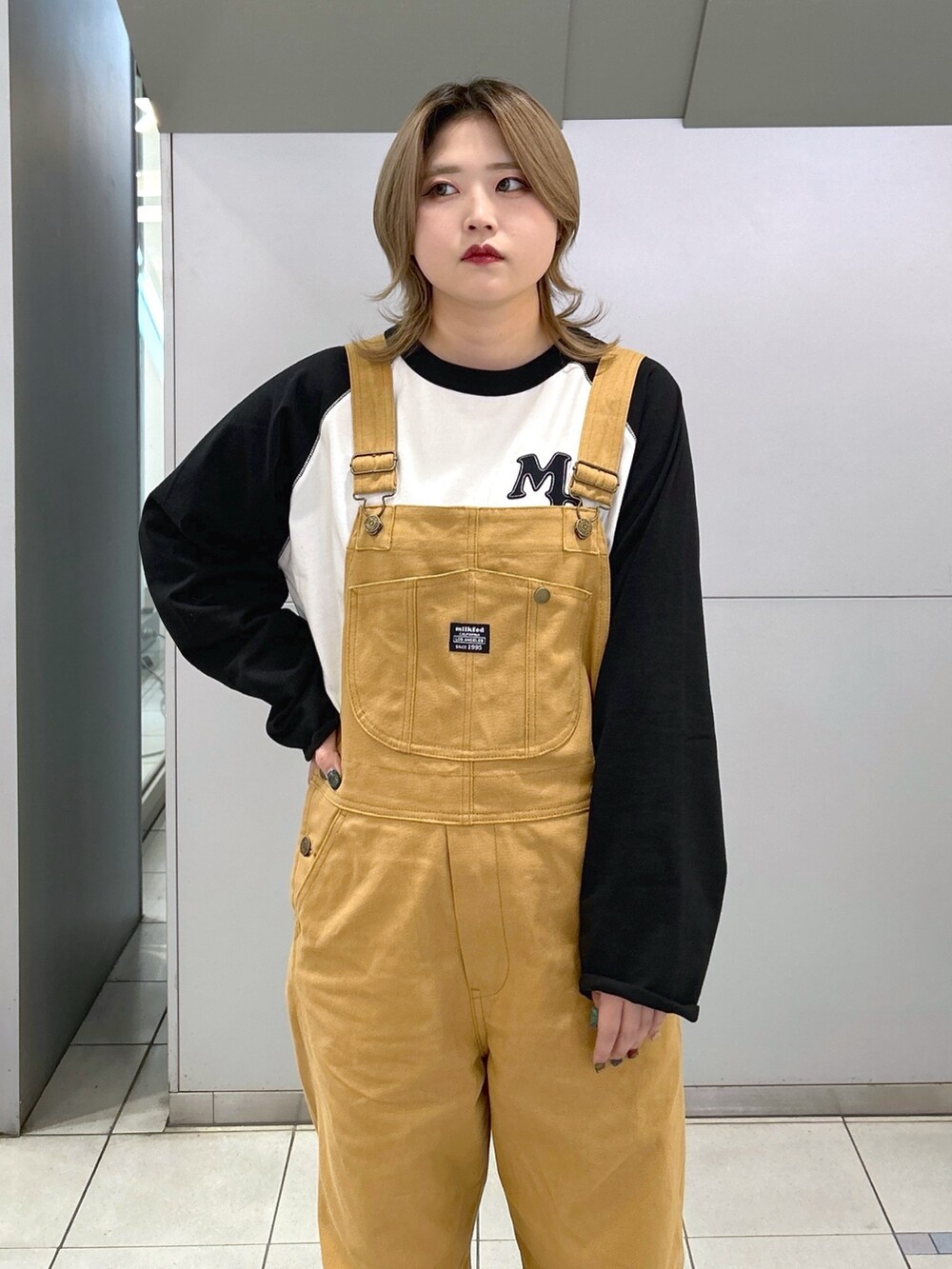 ブラック系のTシャツ/カットソー、ベージュ系のサロペット/オーバーオール、ブラック系のブーツを着用したレディースの冬コーディネートの5枚目の写真