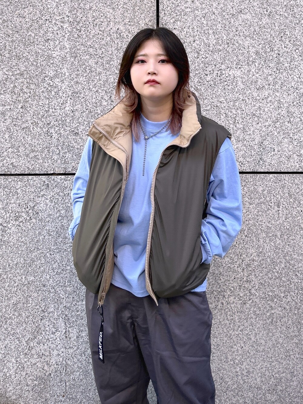 ベージュ系のダウンベスト、ブルー系のTシャツ/カットソー、グレー系のその他パンツを着用したレディースの夏コーディネートの5枚目の写真