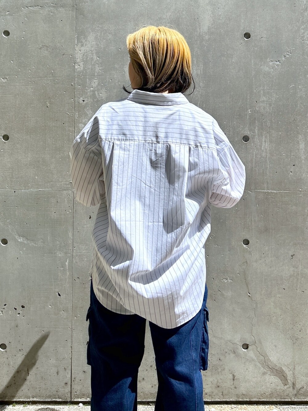 ブルー系のTシャツ/カットソー、ブラウン系のボストンバッグ、ブルー系のカーゴパンツを着用したレディースの春コーディネートの6枚目の写真