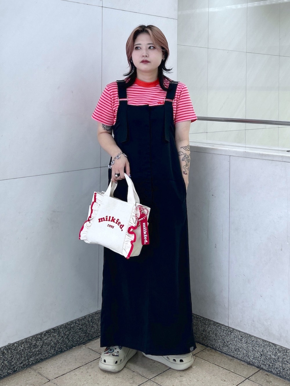 レッド系のTシャツ/カットソー、ブラック系のワンピース、レッド系のショルダーバッグを着用したレディースの夏コーディネートの2枚目の写真