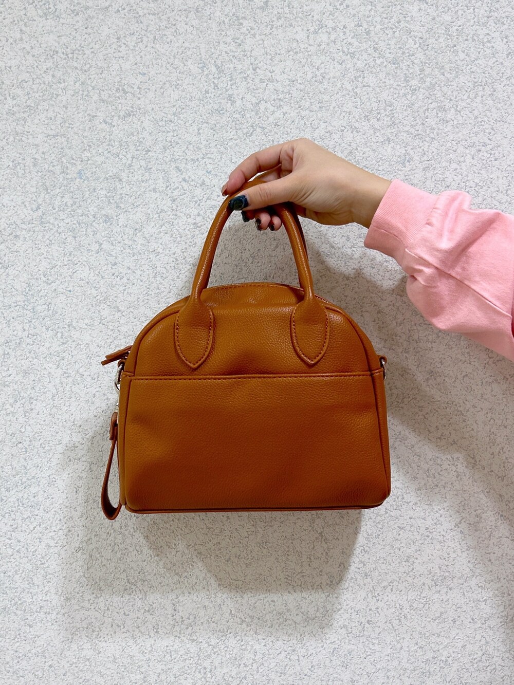 ピンク系のTシャツ/カットソー、ブラック系のデニムパンツ、ブラウン系のボストンバッグを着用したレディースの冬コーディネートの5枚目の写真