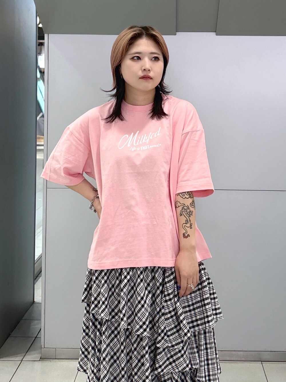 ピンク系のTシャツ/カットソー、ブラック系のスカート、ホワイト系のトートバッグを着用したレディースの夏コーディネートの6枚目の写真