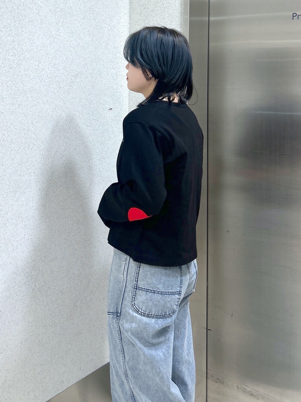 ブルー系のハンドバッグ、ブルー系のデニムパンツ、ベージュ系のサンダルを着用したレディースの夏コーディネートの7枚目の写真