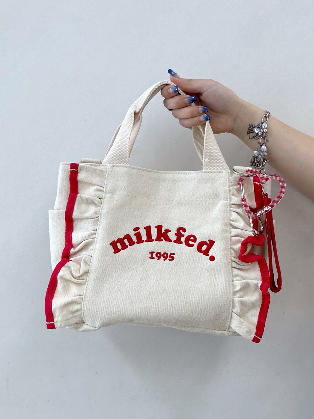 レッド系のTシャツ/カットソー、ブラック系のワンピース、レッド系のショルダーバッグを着用したレディースの夏コーディネートの6枚目の写真