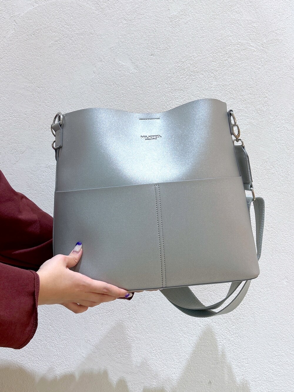 ブラウン系のTシャツ/カットソー、シルバー系のショルダーバッグ、グレー系のジャンパースカートを着用したレディースの秋コーディネートの5枚目の写真