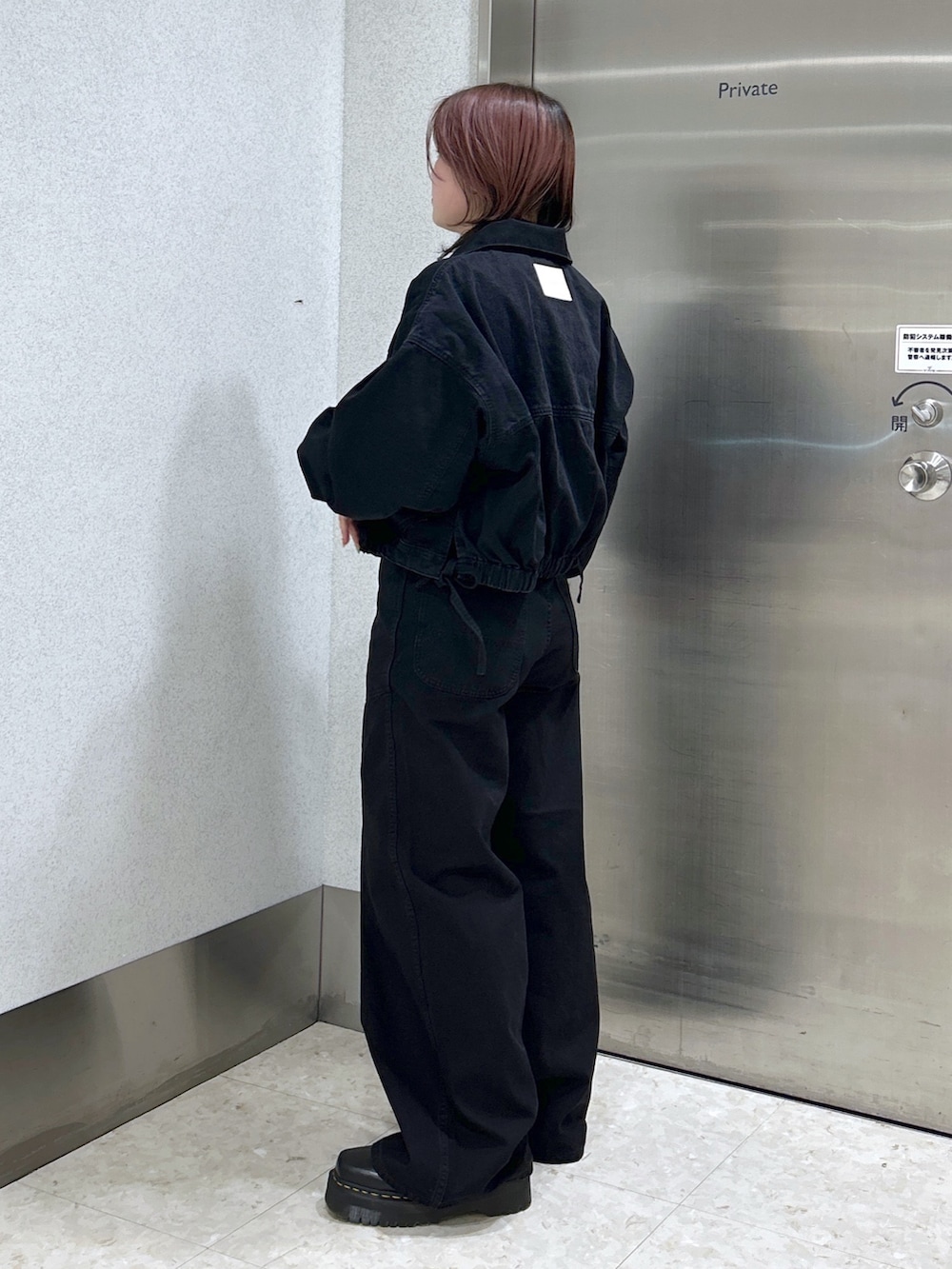 ブラック系のデニムジャケット、ブラック系のデニムパンツ、ブラック系のブーツを着用したレディースの冬コーディネートの3枚目の写真