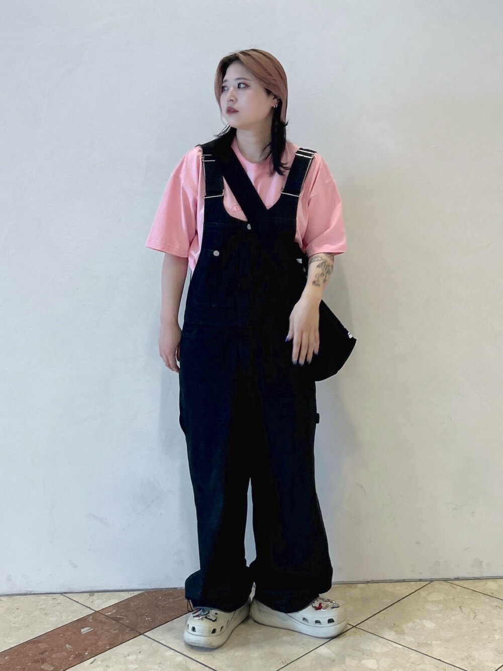 ピンク系のTシャツ/カットソー、ブラック系のショルダーバッグ、ブラック系のサロペット/オーバーオールを着用したレディースの夏コーディネートの4枚目の写真