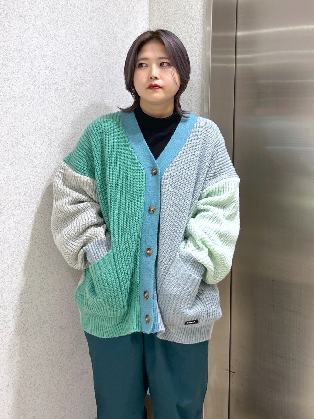 ブラック系のTシャツ/カットソー、グリーン系のカーディガン/ボレロ、グリーン系のその他パンツを着用したレディースの秋コーディネートの4枚目の写真