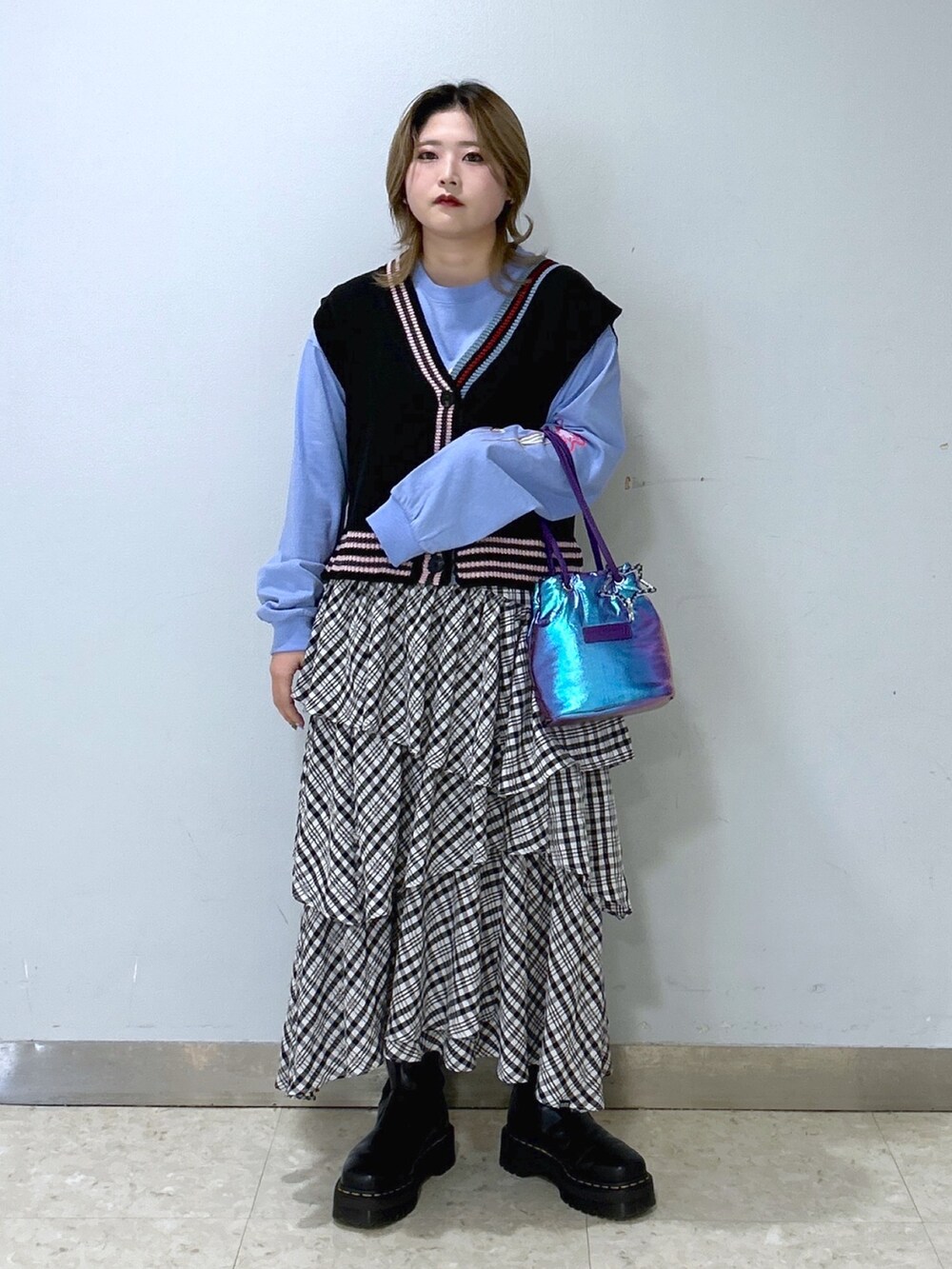 ブラック系のベスト、ブルー系のTシャツ/カットソー、ブラック系のスカートを着用したレディースの冬コーディネートの2枚目の写真