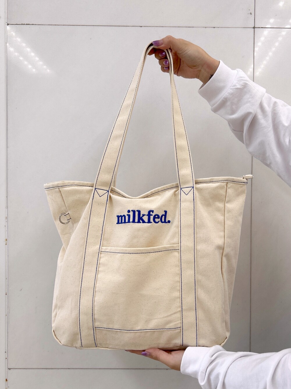 ホワイト系のTシャツ/カットソー、ブルー系のデニムパンツ、ブルー系のトートバッグを着用したレディースの秋コーディネートの4枚目の写真