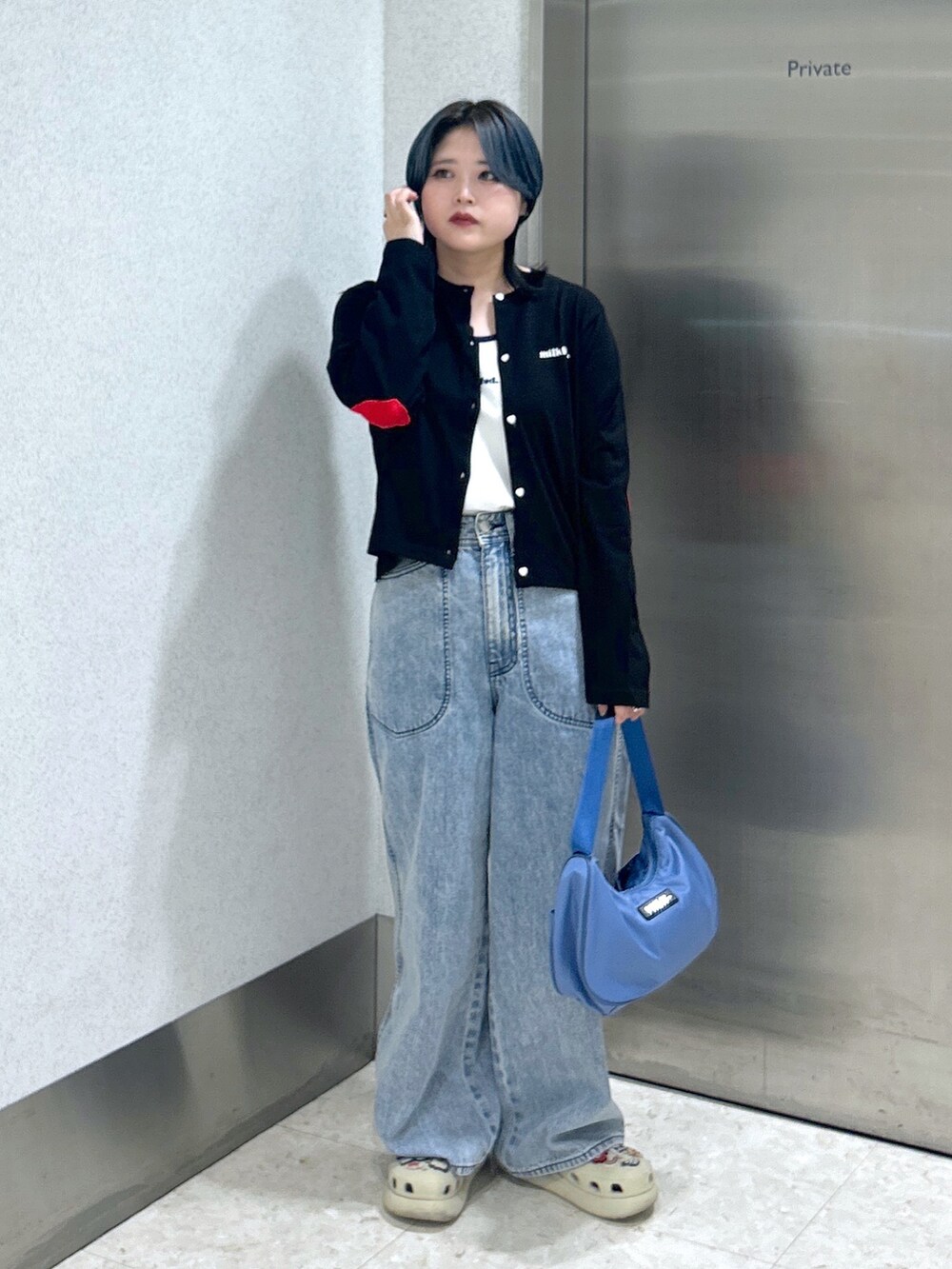 ブルー系のハンドバッグ、ブルー系のデニムパンツ、ベージュ系のサンダルを着用したレディースの夏コーディネートの2枚目の写真