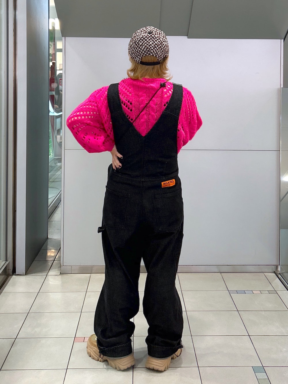 ピンク系のニット/セーター、ブラック系のサロペット/オーバーオール、パープル系のショルダーバッグを着用したレディースの秋コーディネートの3枚目の写真