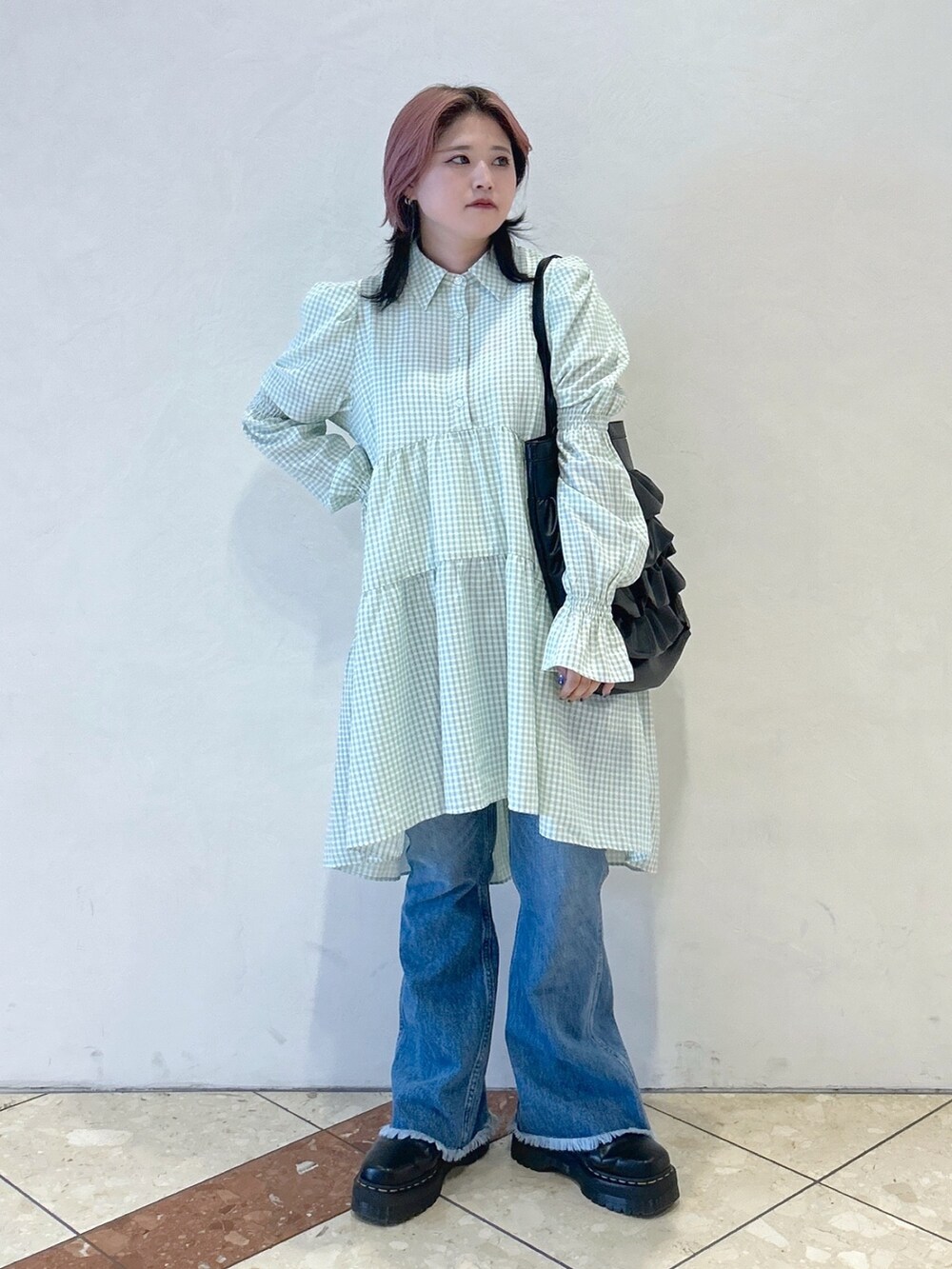 グリーン系のワンピース、ブルー系のデニムパンツ、ブラック系のトートバッグを着用したレディースの夏コーディネートの2枚目の写真
