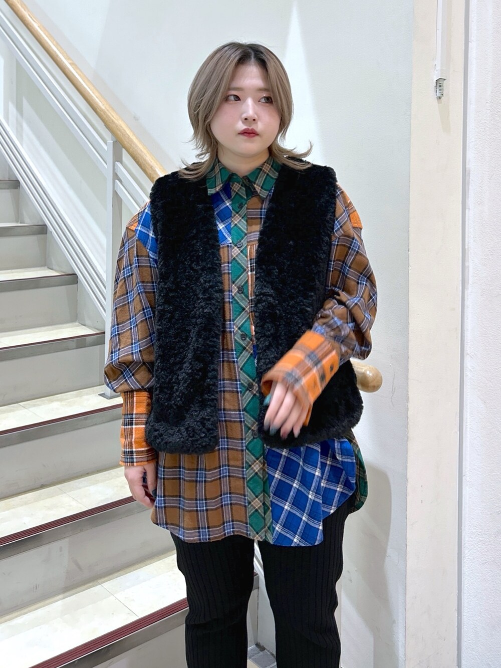 パープル系のショルダーバッグ、ブラック系のベスト、ブラウン系のシャツ/ブラウスを着用したレディースの冬コーディネートの3枚目の写真