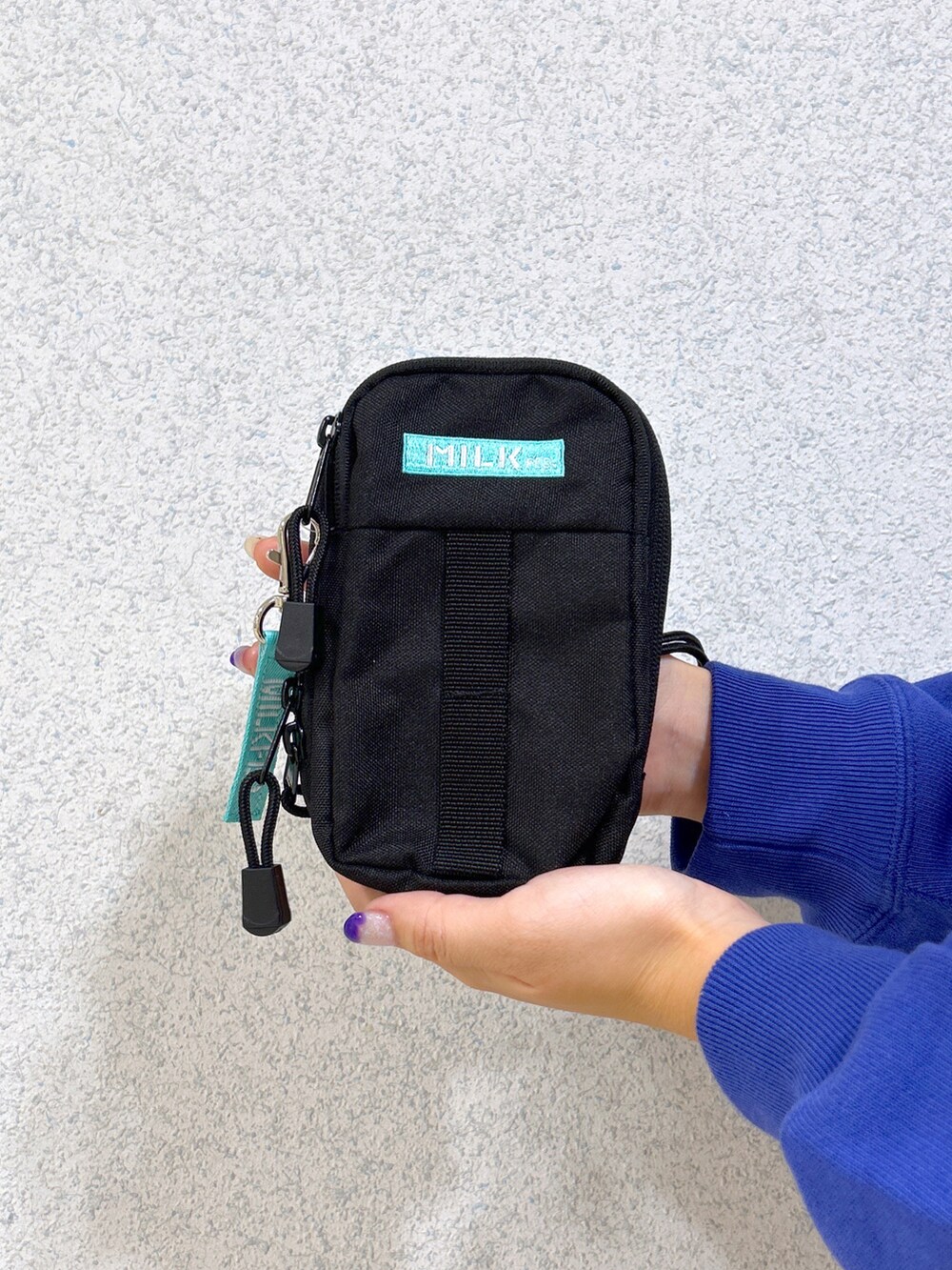 ブルー系のスウェット、ブルー系のスカート、ベージュ系のスニーカーを着用したレディースの秋コーディネートの4枚目の写真