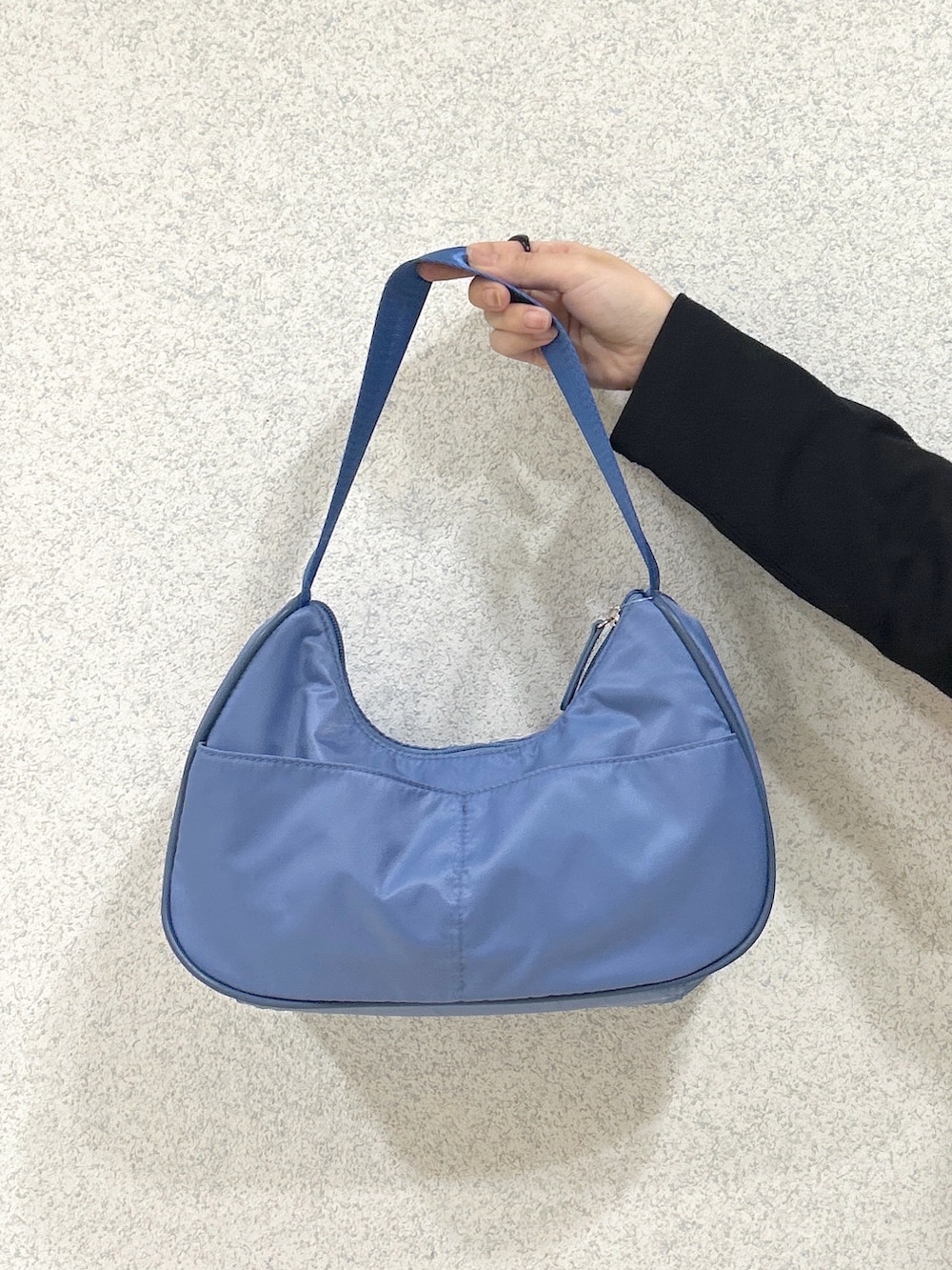 ブルー系のハンドバッグ、ブルー系のデニムパンツ、ベージュ系のサンダルを着用したレディースの夏コーディネートの10枚目の写真