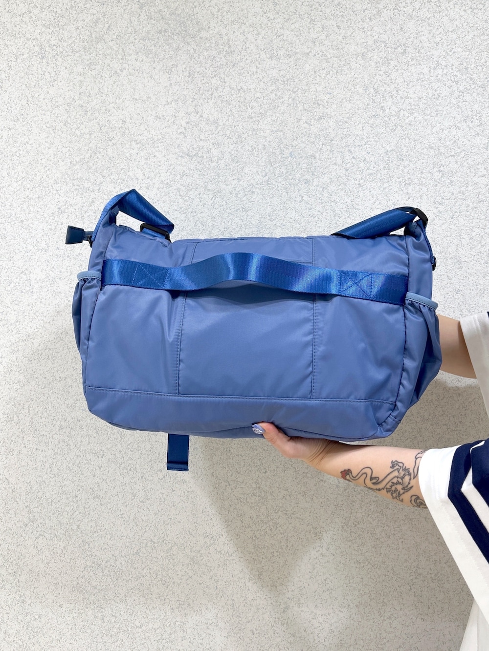 ブルー系のメッセンジャーバッグ、ホワイト系のTシャツ/カットソー、ブルー系のその他パンツを着用したレディースの春コーディネートの9枚目の写真