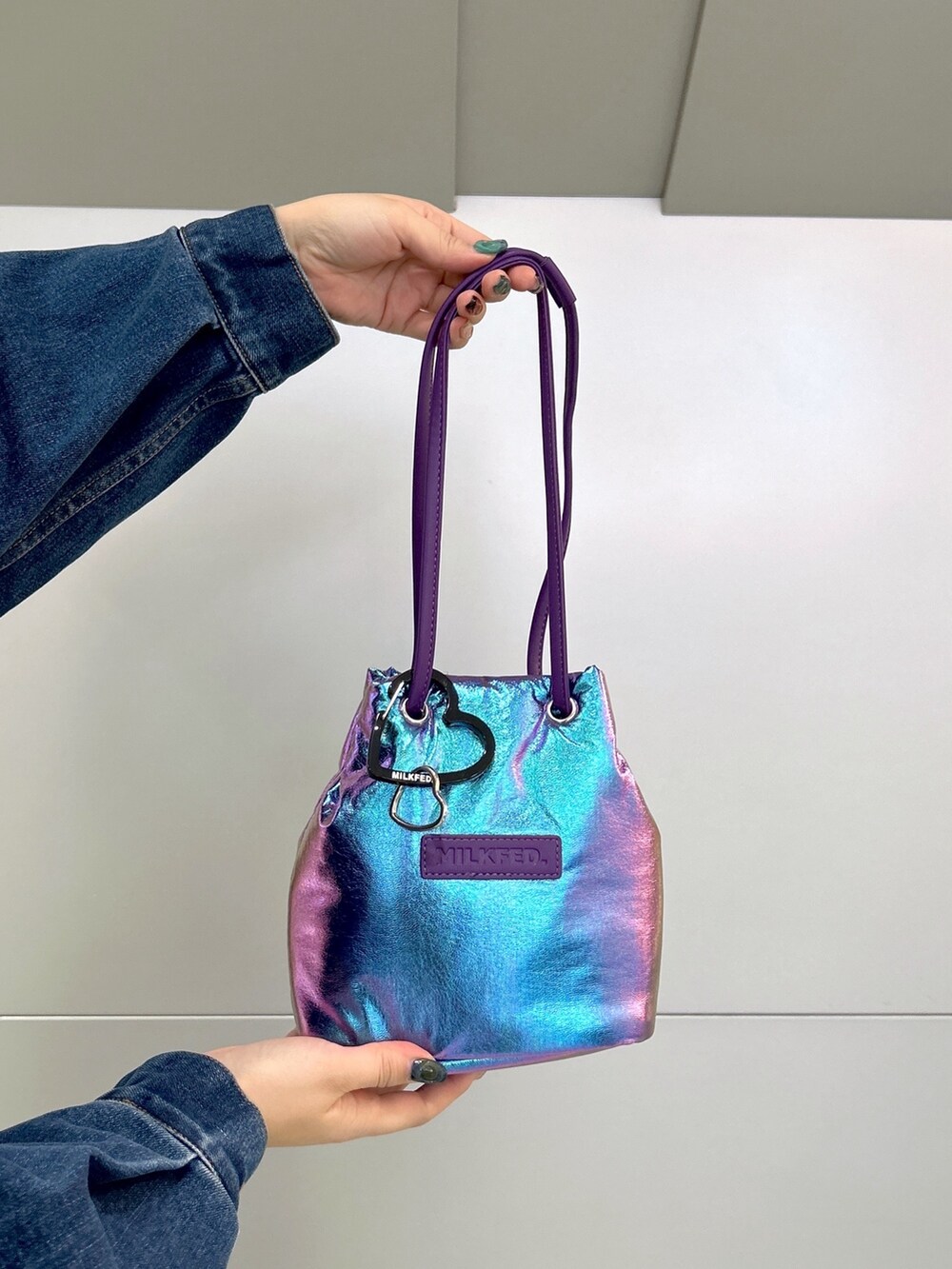 グリーン系のジャンパースカート、ブラック系のブーツ、ブルー系のデニムジャケットを着用したレディースの冬コーディネートの7枚目の写真