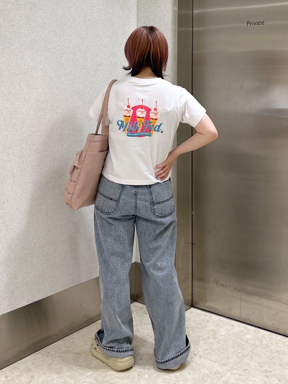 ブルー系のデニムパンツ、ピンク系のトートバッグ、ベージュ系のサンダルを着用したレディースの夏コーディネートの3枚目の写真