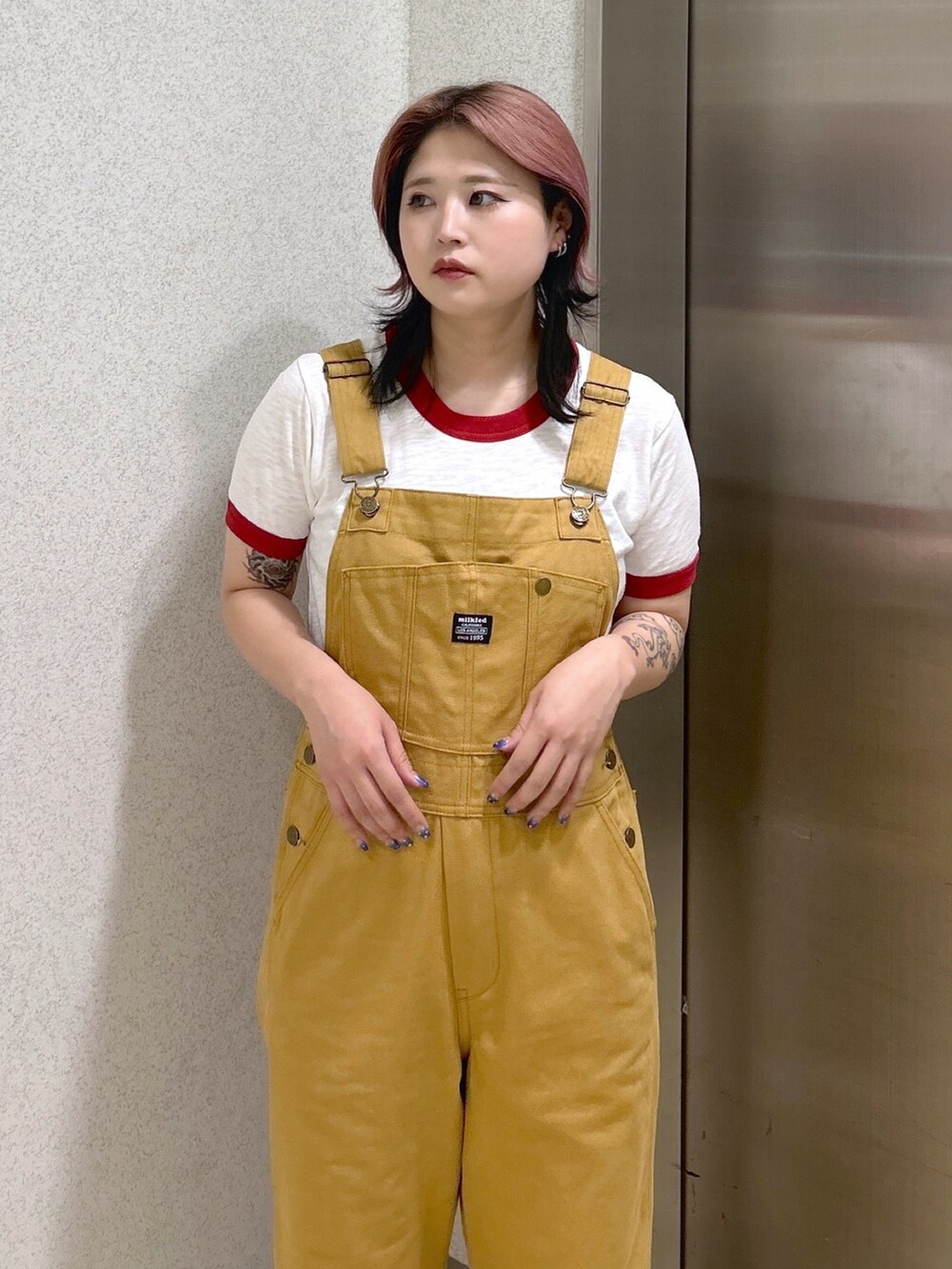 レッド系のTシャツ/カットソー、ベージュ系のサロペット/オーバーオール、ブラック系のトートバッグを着用したレディースの夏コーディネートの5枚目の写真