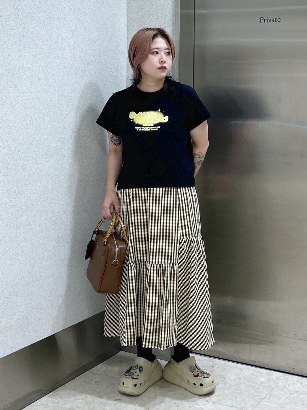 ブラウン系のショルダーバッグ、ベージュ系のサンダル、ブラウン系のスカートを着用したレディースの夏コーディネートの2枚目の写真