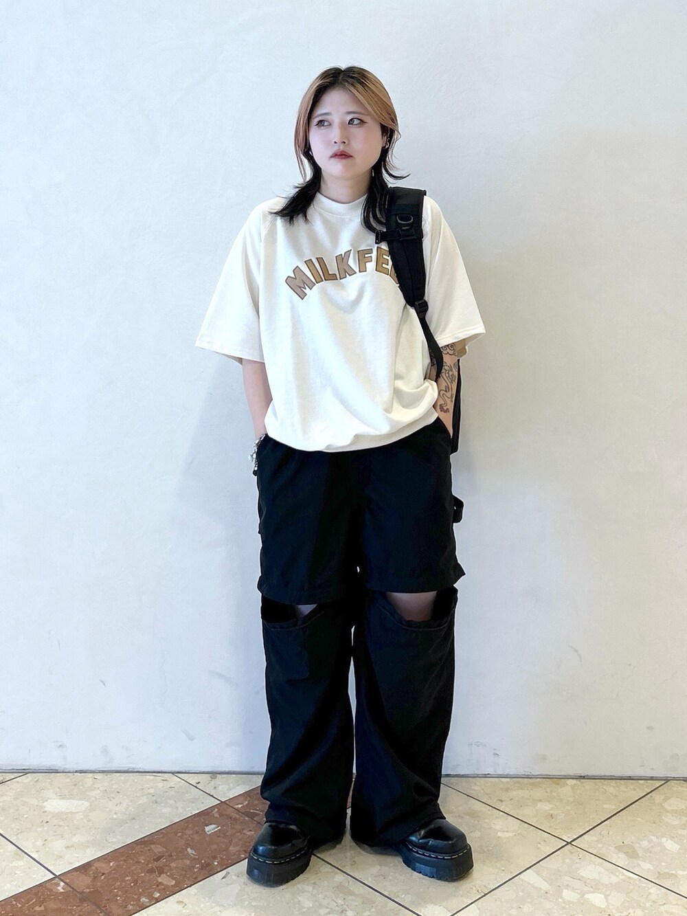 ブラック系のその他パンツ、ブラック系のブーツ、ホワイト系のTシャツ/カットソーを着用したレディースの夏コーディネートの3枚目の写真