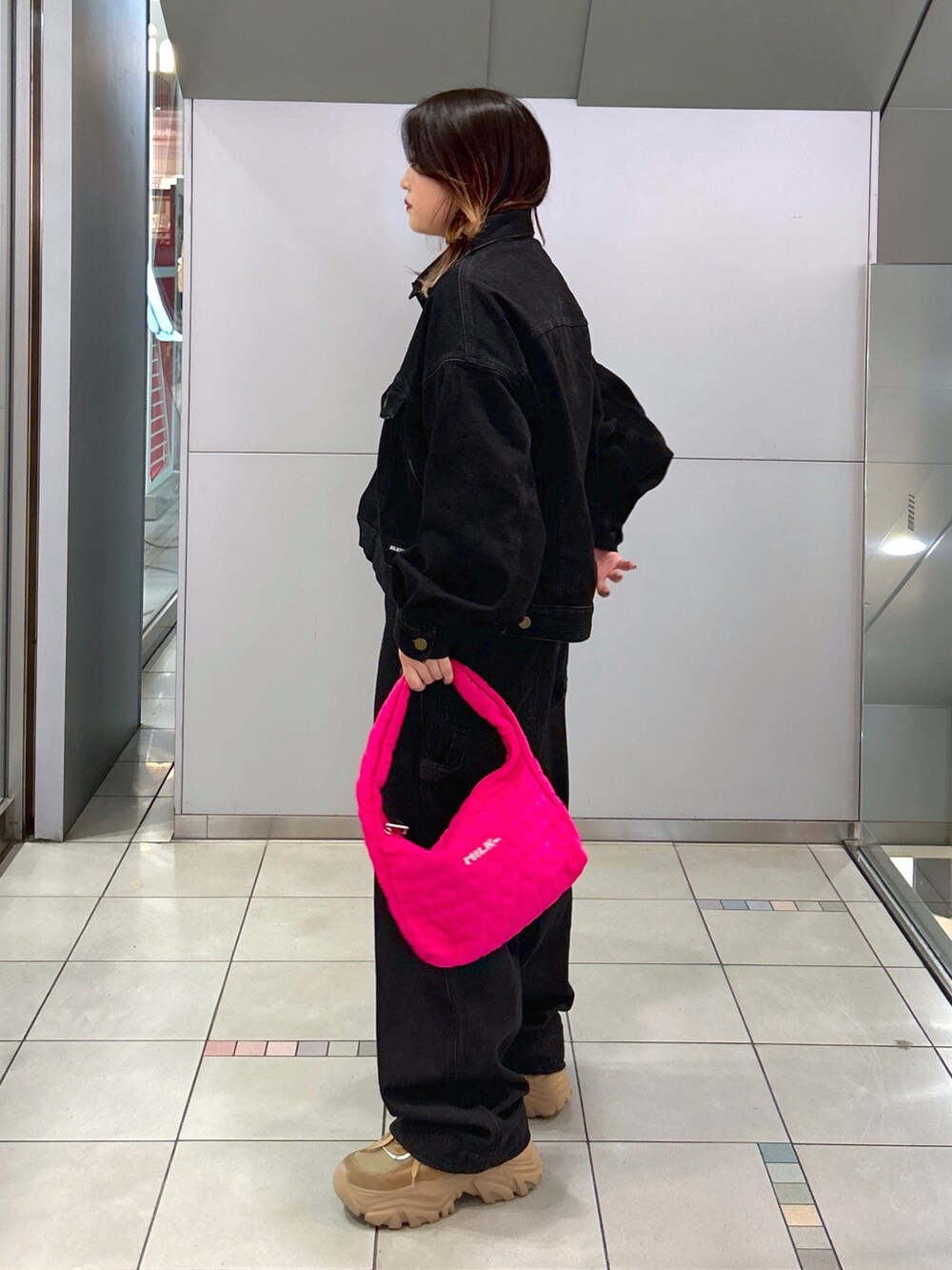 ブラック系のデニムジャケット、ブラック系のサロペット/オーバーオール、ピンク系のハンドバッグを着用したレディースの秋コーディネートの2枚目の写真