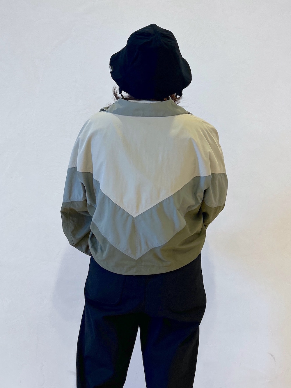 グレー系のTシャツ/カットソー、ベージュ系のナイロンジャケット、ブラック系のサロペット/オーバーオールを着用したレディースの春コーディネートの7枚目の写真