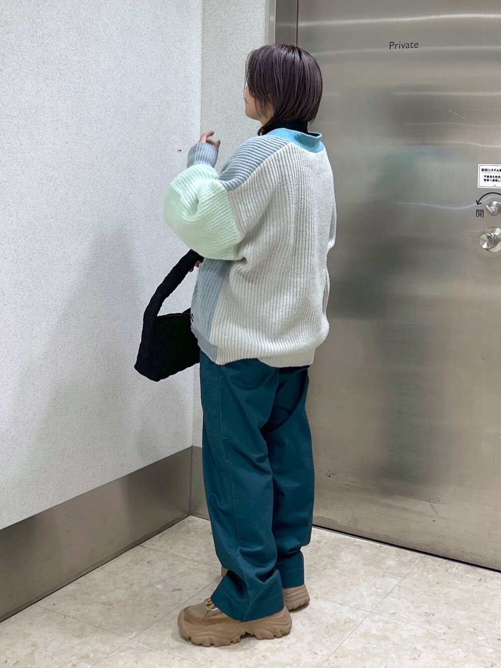 ブラック系のTシャツ/カットソー、グリーン系のカーディガン/ボレロ、グリーン系のその他パンツを着用したレディースの秋コーディネートの2枚目の写真