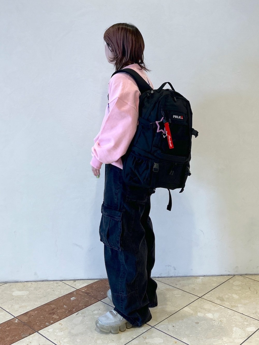 ブラック系のバックパック/リュック、ピンク系のスウェット、ブラック系のカーゴパンツを着用したレディースの春コーディネートの4枚目の写真