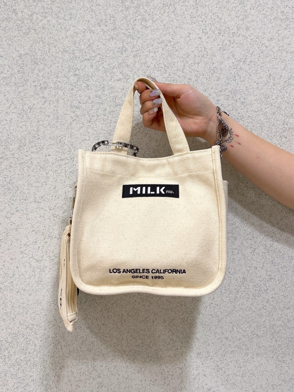 ホワイト系のショルダーバッグ、ブラック系のタンクトップ、ブラック系のTシャツ/カットソーを着用したレディースの春コーディネートの6枚目の写真