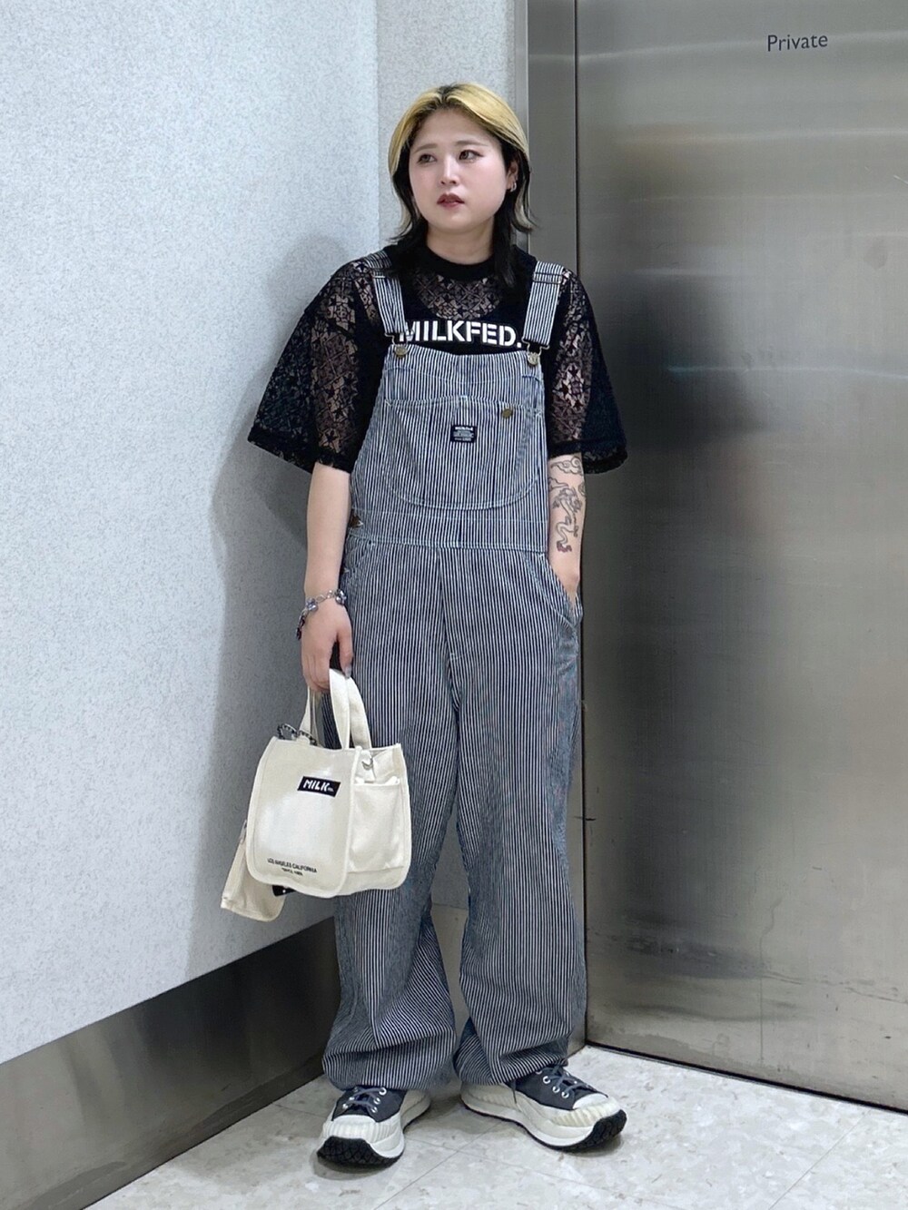 ホワイト系のショルダーバッグ、ブラック系のタンクトップ、ブラック系のTシャツ/カットソーを着用したレディースの春コーディネートの2枚目の写真