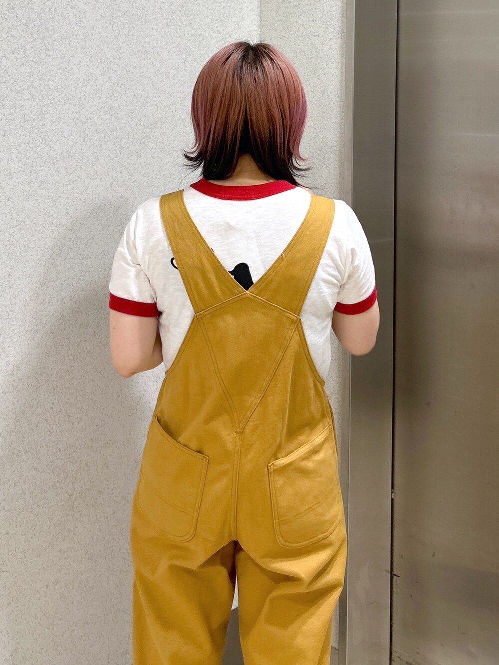 レッド系のTシャツ/カットソー、ベージュ系のサロペット/オーバーオール、ブラック系のトートバッグを着用したレディースの夏コーディネートの6枚目の写真